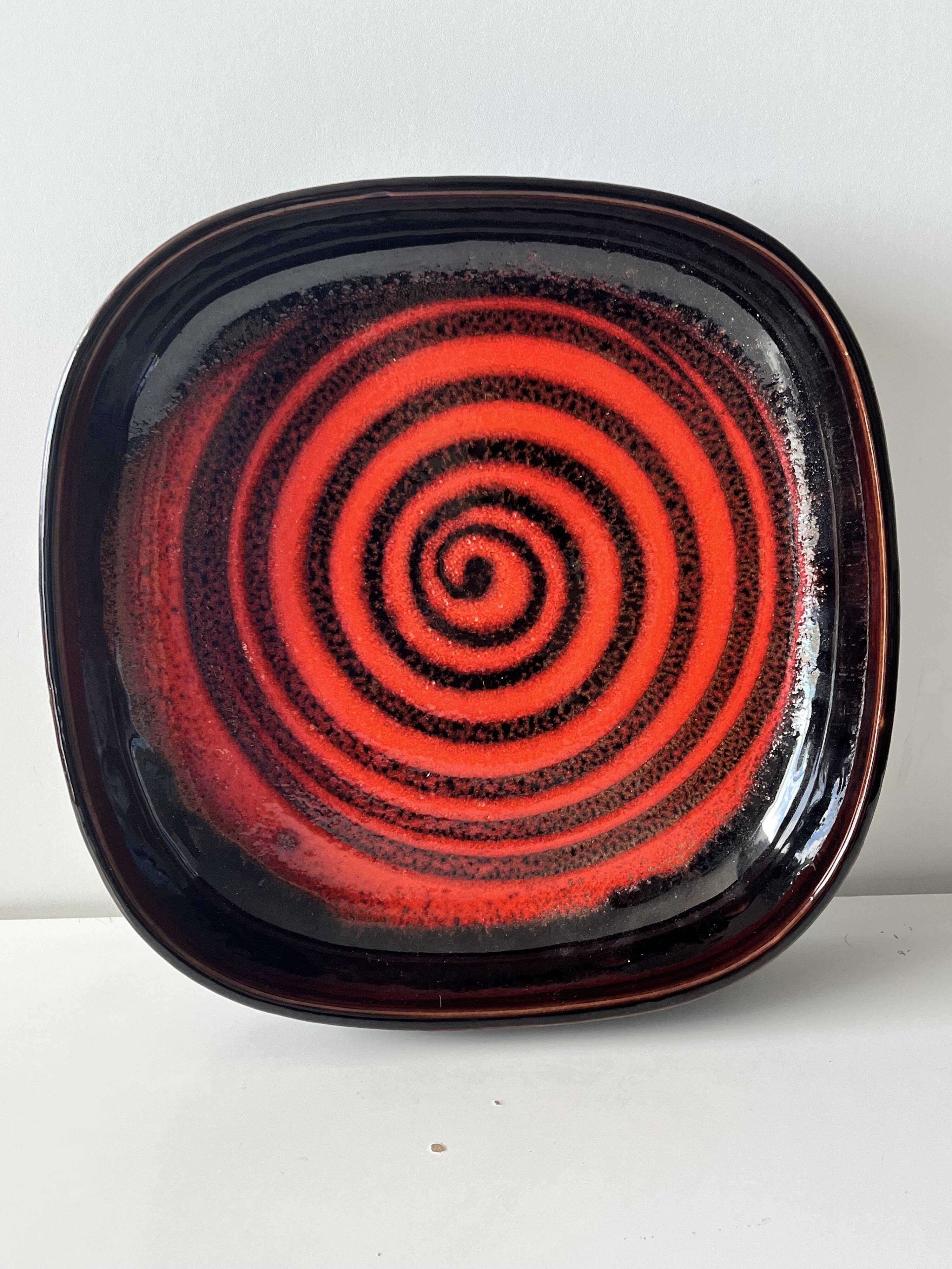 Large decorative ceramic catchall with red and black spiral pattern.