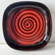 Large decorative ceramic catchall with red and black spiral pattern.