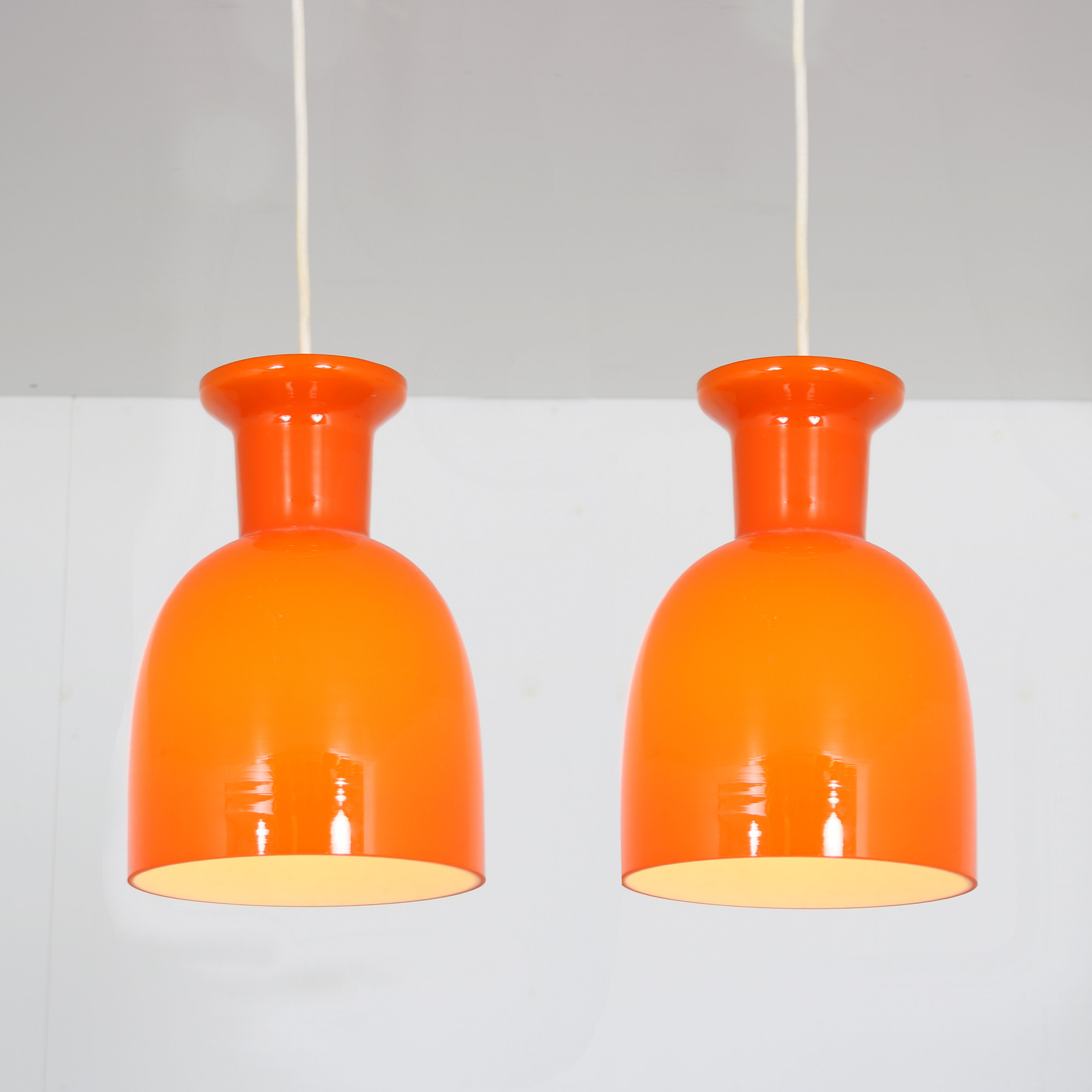 Pair of orange hanging lamps by Raak, the Netherlands, 1970