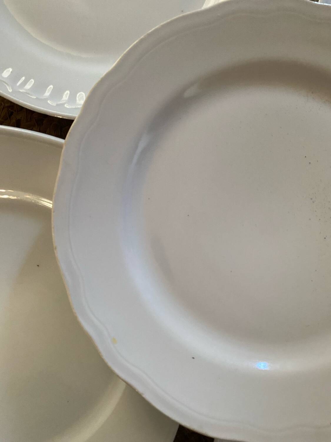 5 mismatched old white plates.