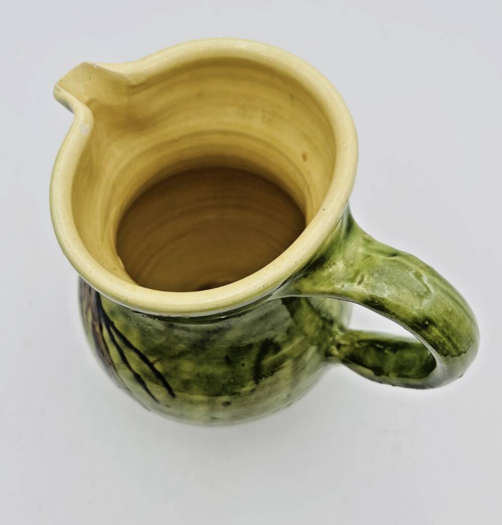 Green stoneware pitcher with flower and brown bird decoration