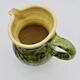 Green stoneware pitcher with flower and brown bird decoration