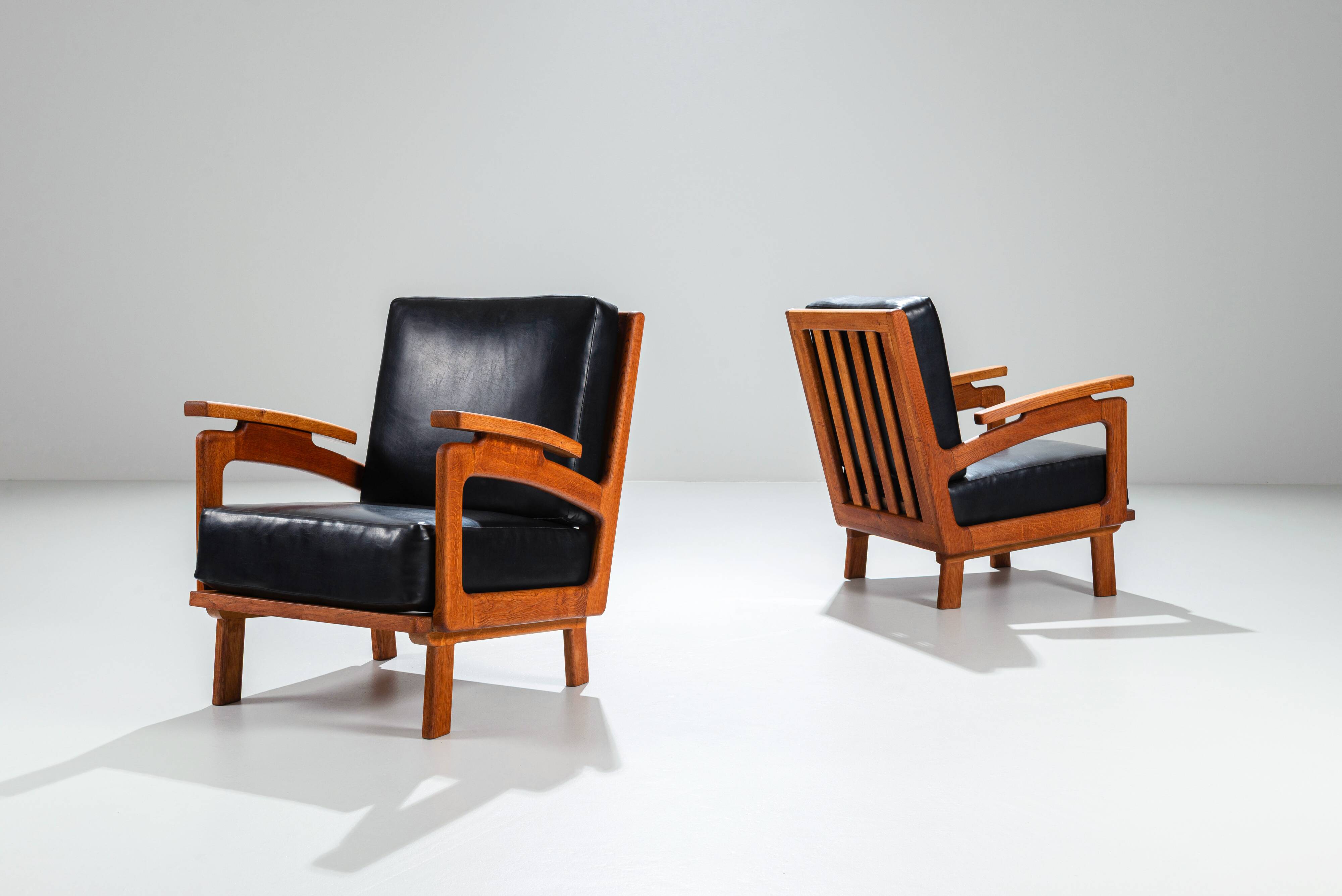 Pair of Belgian lounge chairs in solid oak with leather cushions