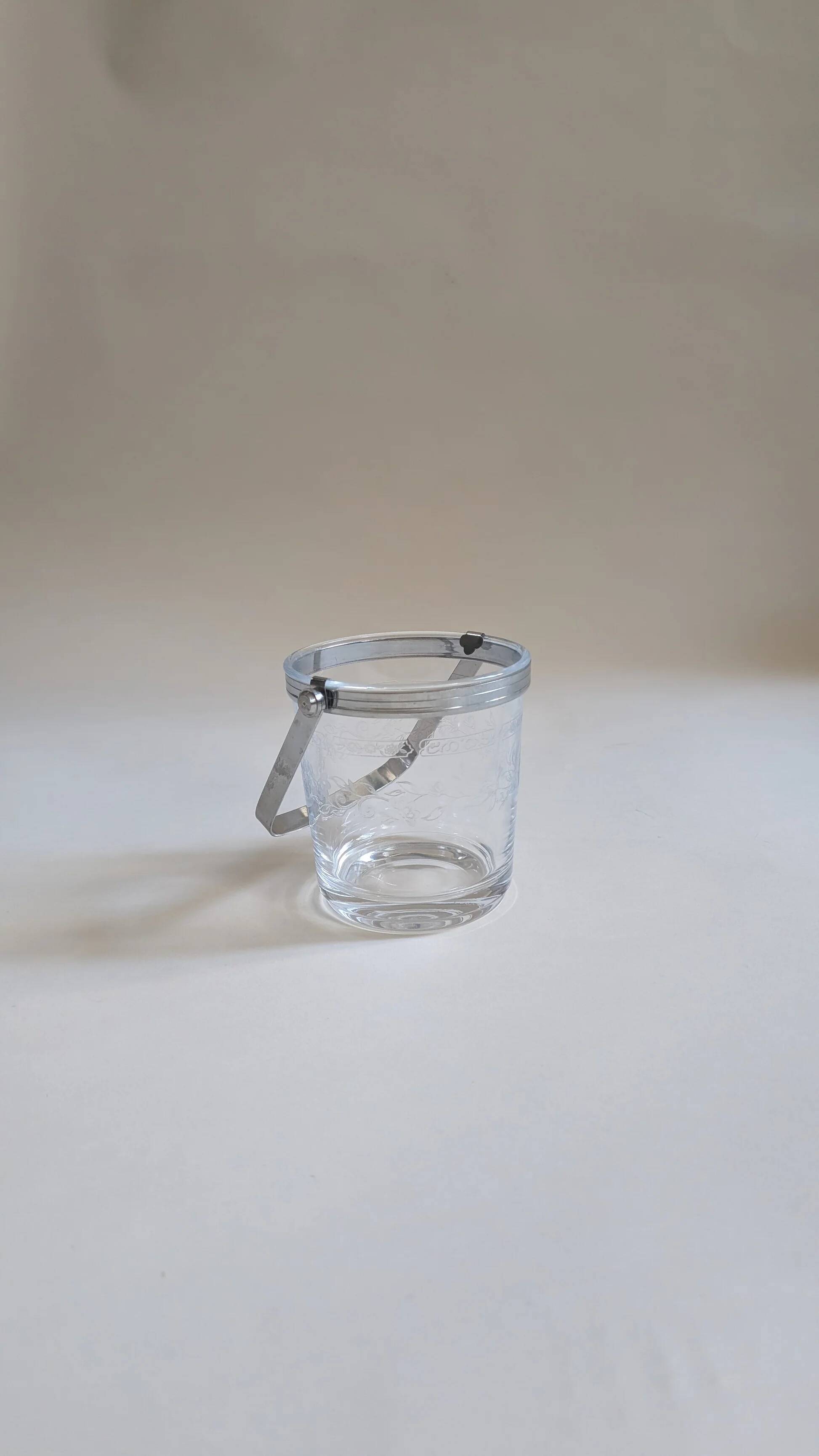 Clear glass ice bucket with an etched floral design
