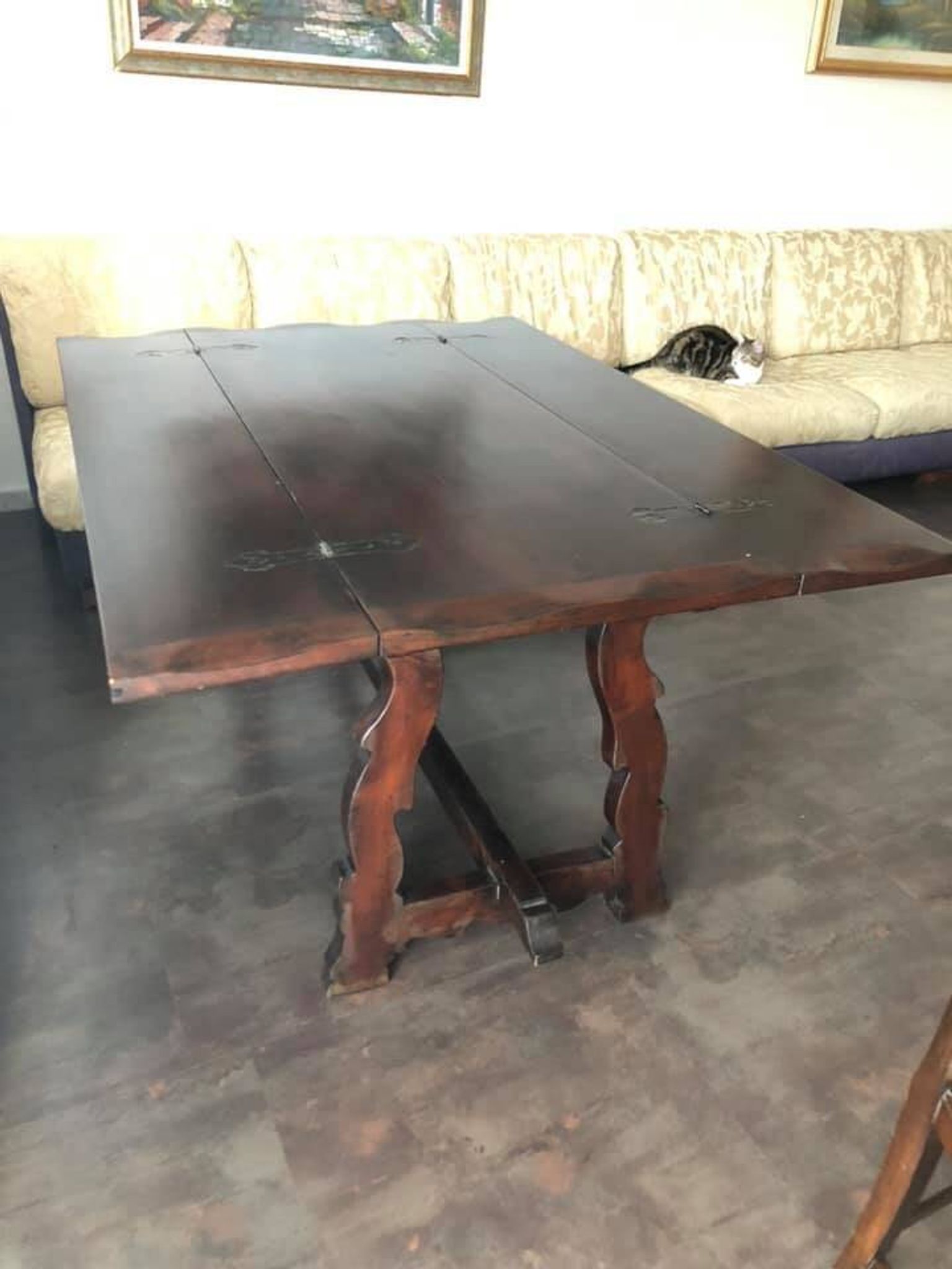 19th-century brown walnut dining table with sculpted trestle legs.