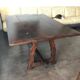 19th-century brown walnut dining table with sculpted trestle legs.