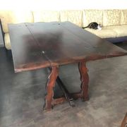 19th-century brown walnut dining table with sculpted trestle legs.