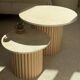 Round nesting coffee table in travertine and raw fluted wood.