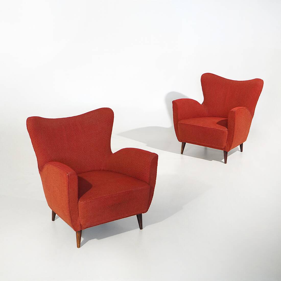 Pair of red armchairs with cone-shaped feet, 1950s