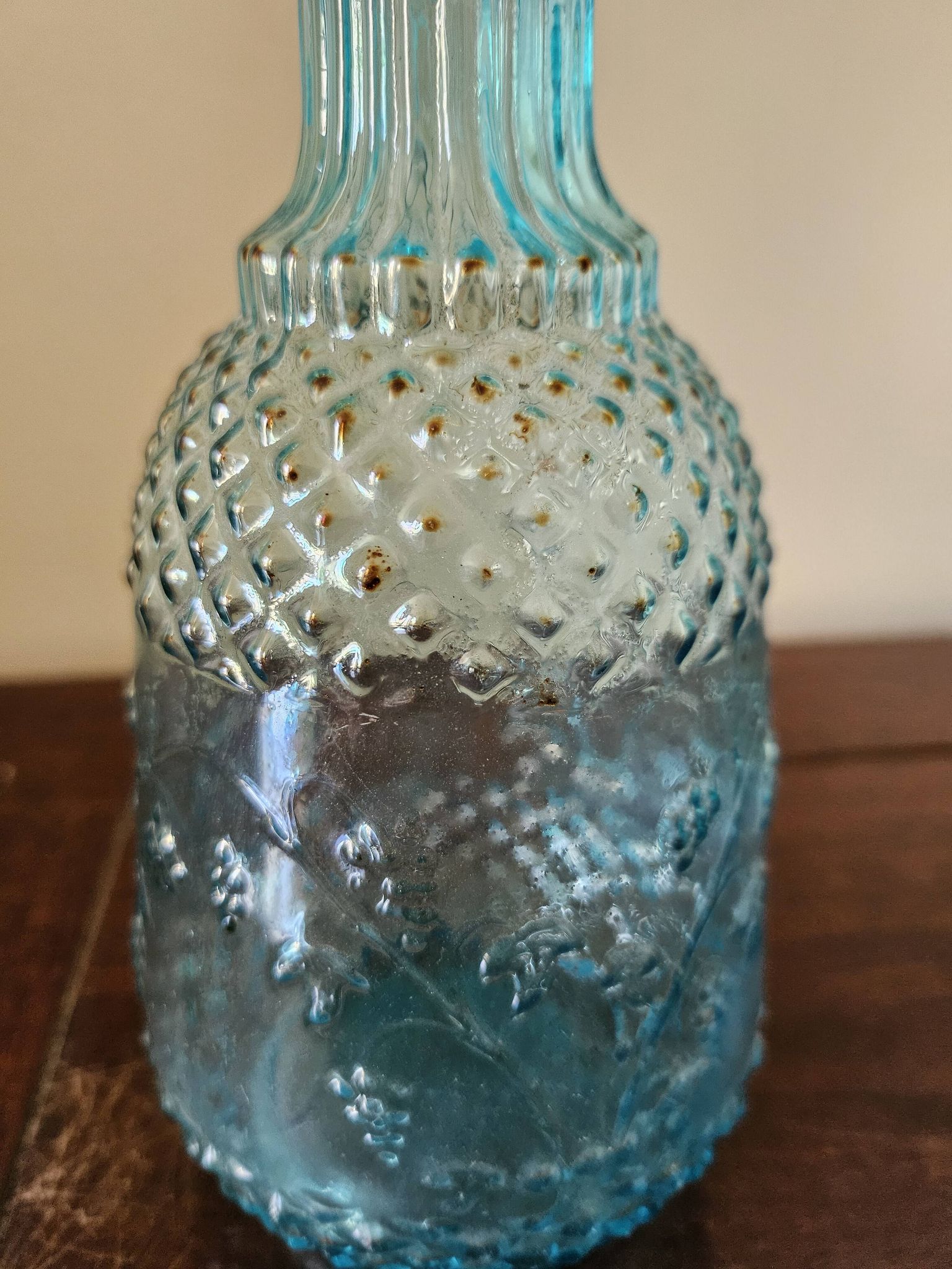 Small vintage turquoise blue glass carafe with floral design.