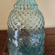 Small vintage turquoise blue glass carafe with floral design.