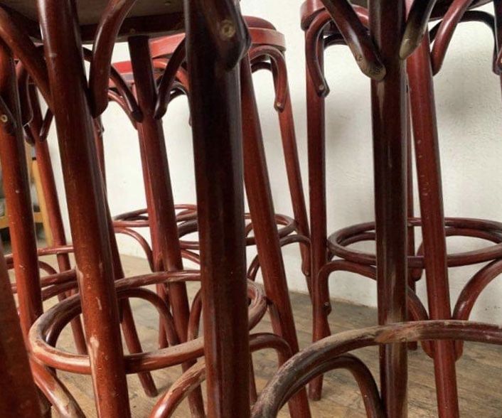 Series of 9 bistro bar stools in curved wooden restaurant sitting red fabric