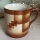 Vintage 70s old ceramic mug with a brown cubic graphic pattern.