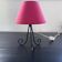 Black metal tripod lamp with red cotton.
