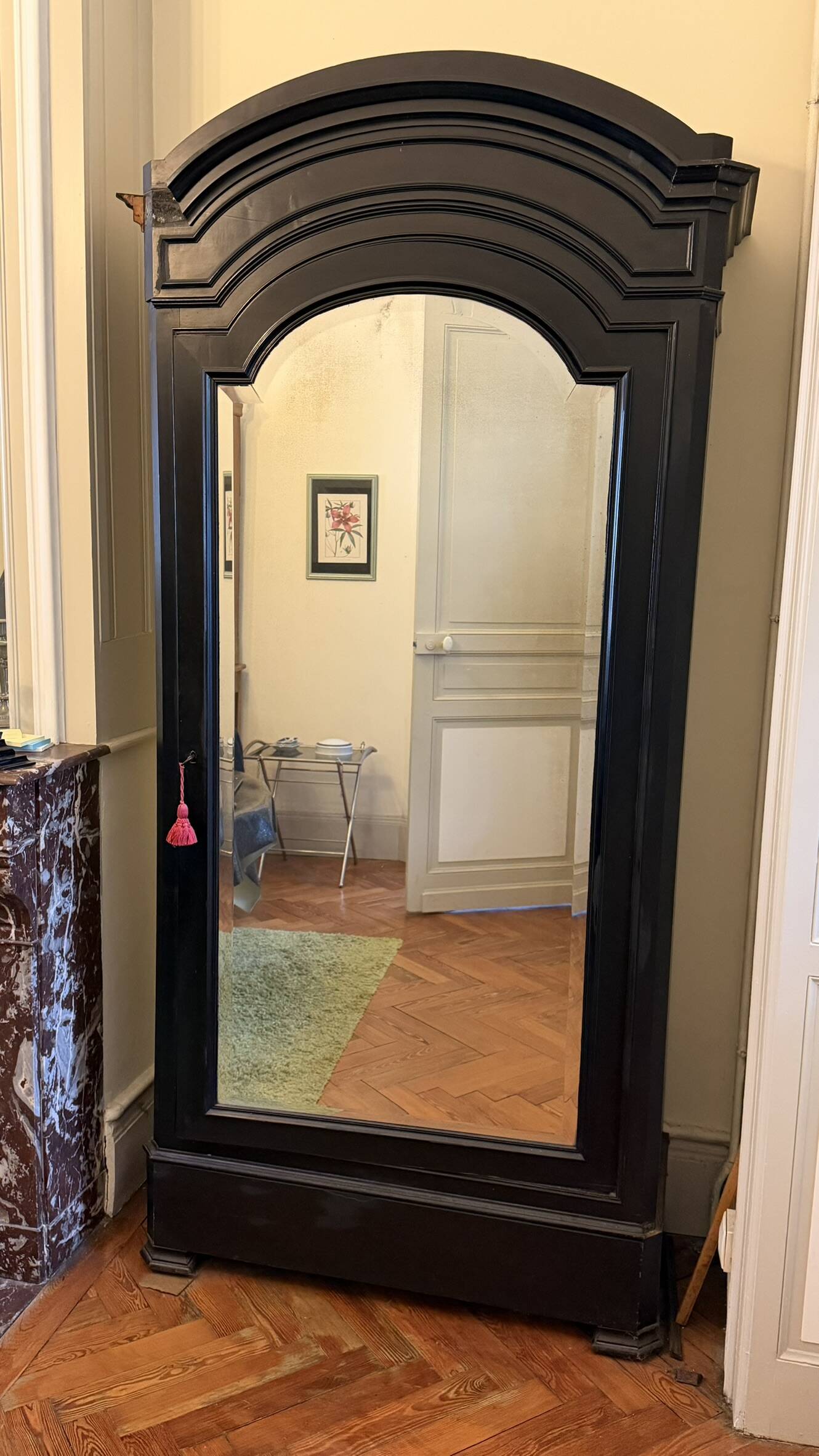 Black wardrobe with a mirrored door in ebony finish.