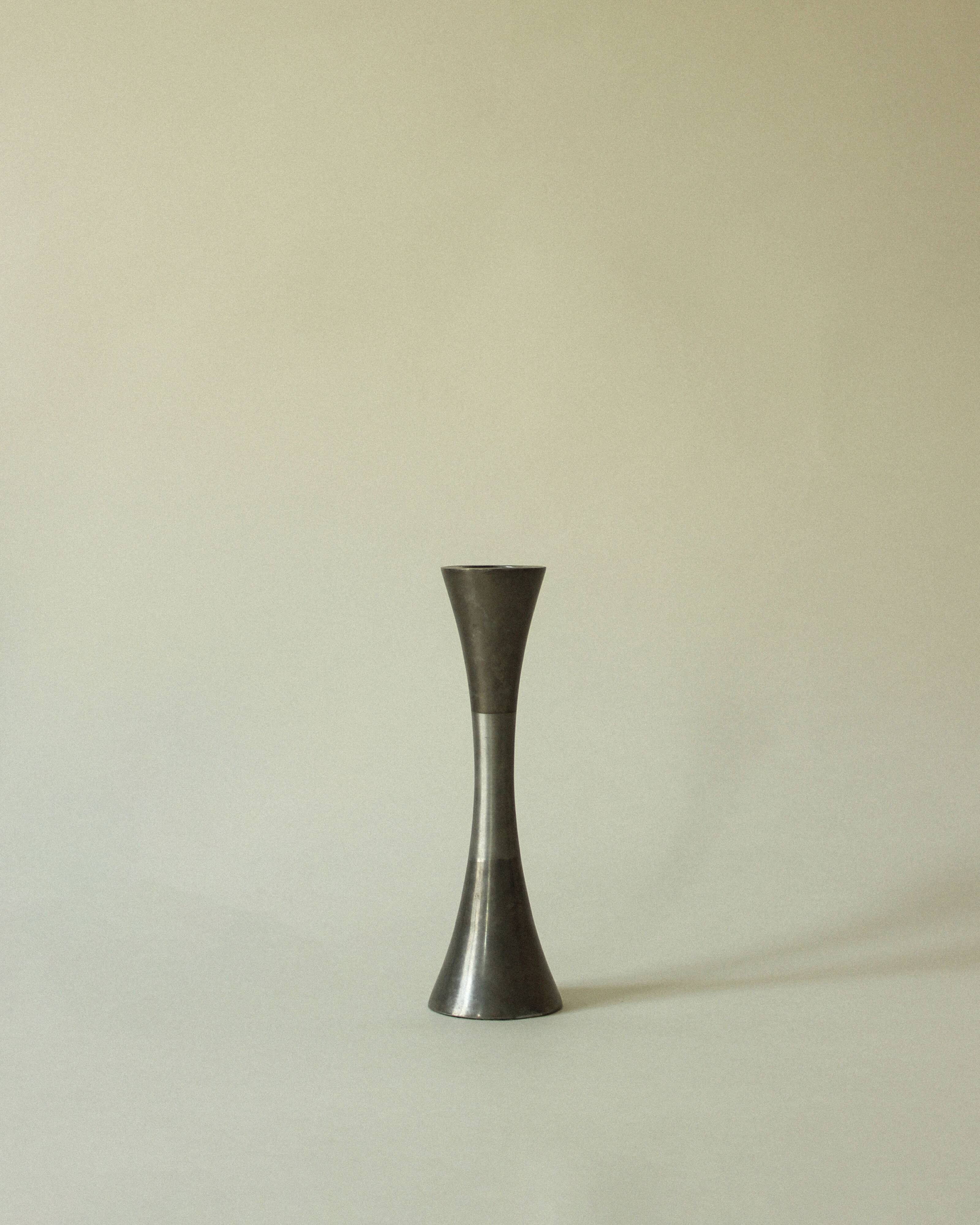 Set of three diabolo-shaped candle holders made of cast steel.