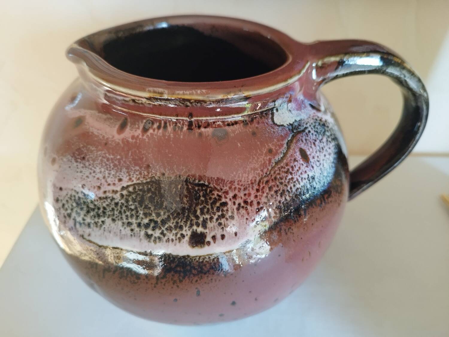 Stoneware pitcher by Matthieu Liévois in shades of red