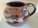 Stoneware pitcher by Matthieu Liévois in shades of red