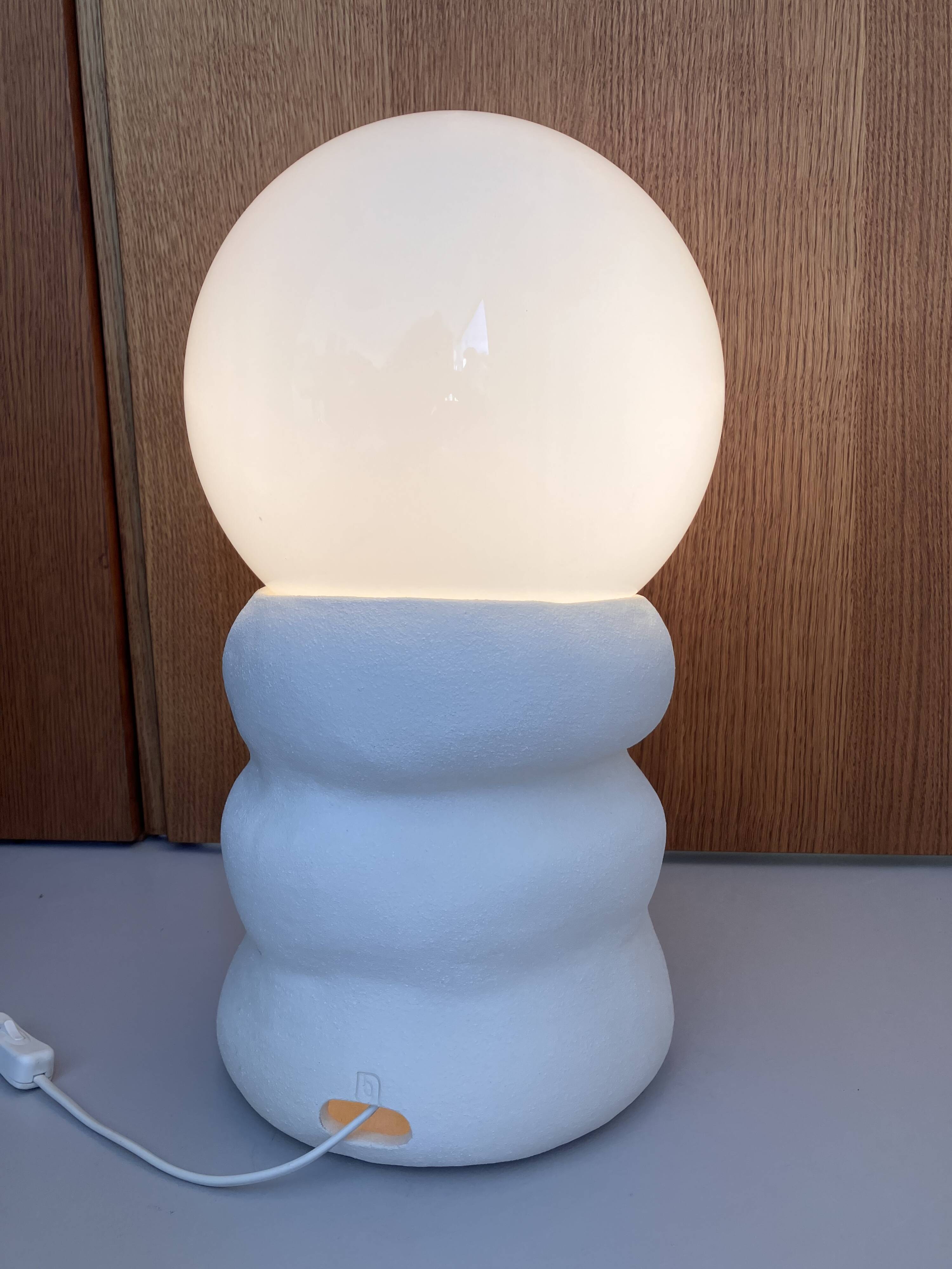 Large table lamp in off-white ceramic with an organic globe shape.
