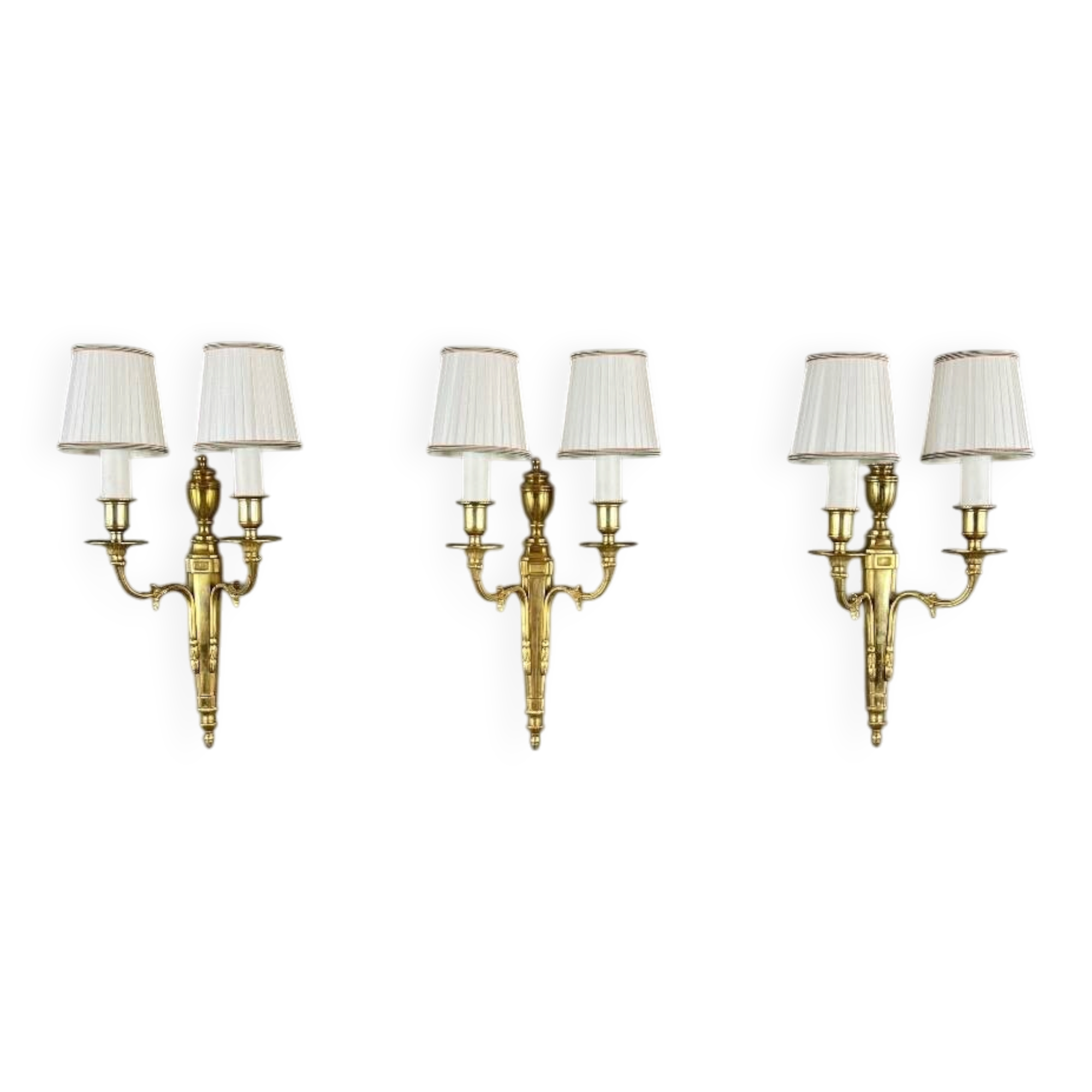 Set of three Louis XVI style wall sconces in gilded bronze, 20th century.