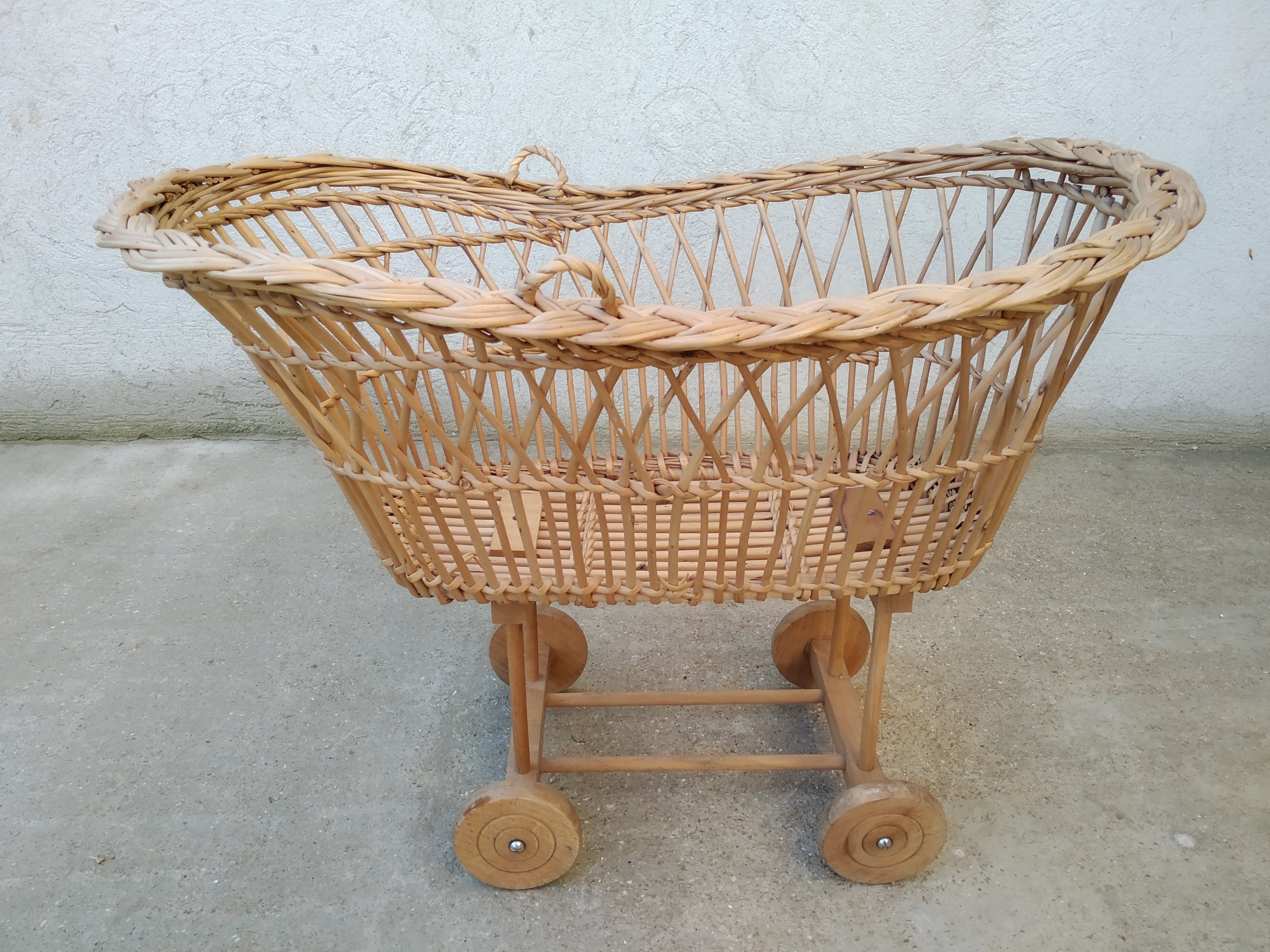 Rattan cradle for doll on vintage wheels