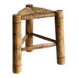 Antique tripod stool in light wood with a woven straw seat.