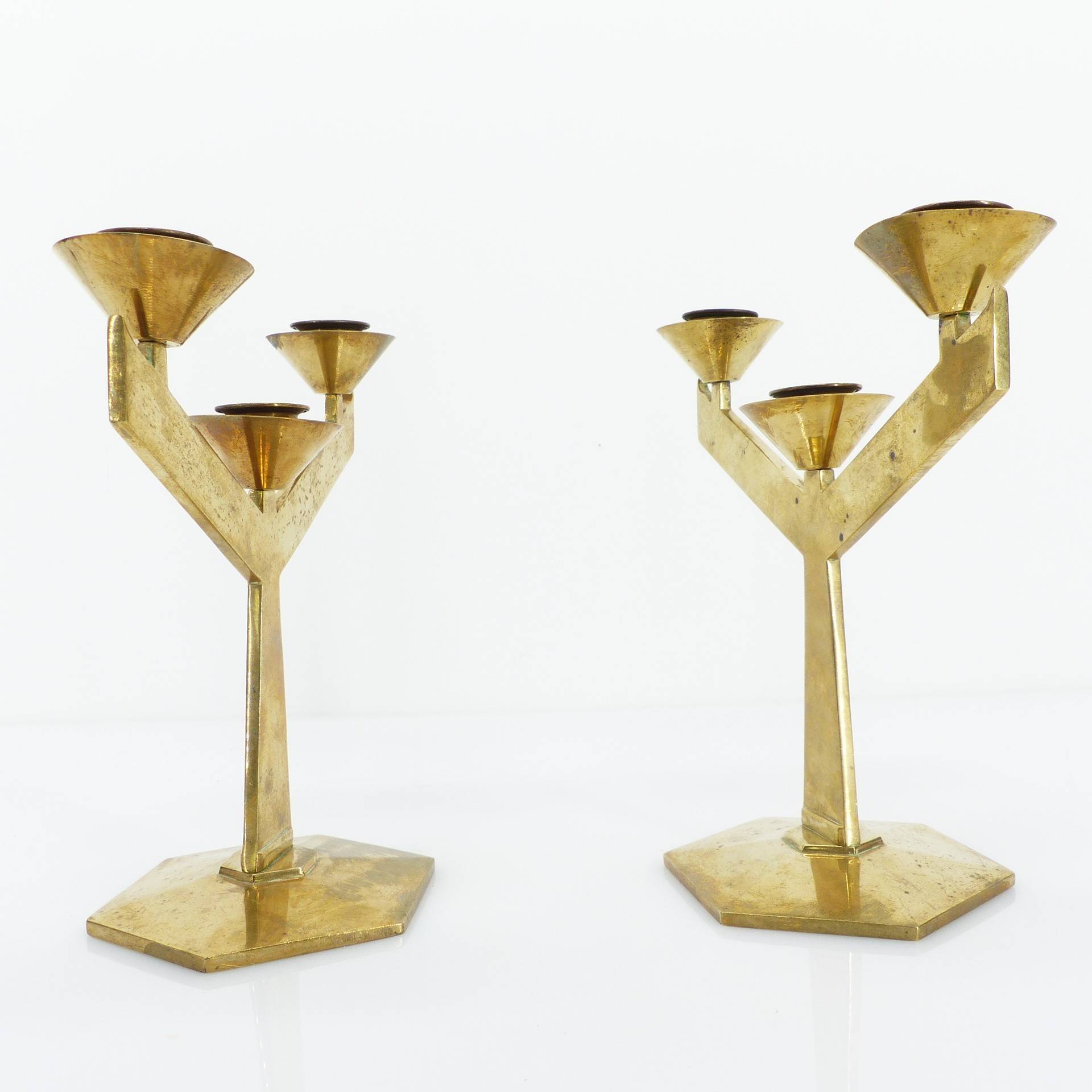 Pair of modernist three-armed solid brass candlesticks, circa 1960