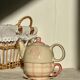 Vintage porcelain teapot and cup set with pink and beige floral and gingham pattern