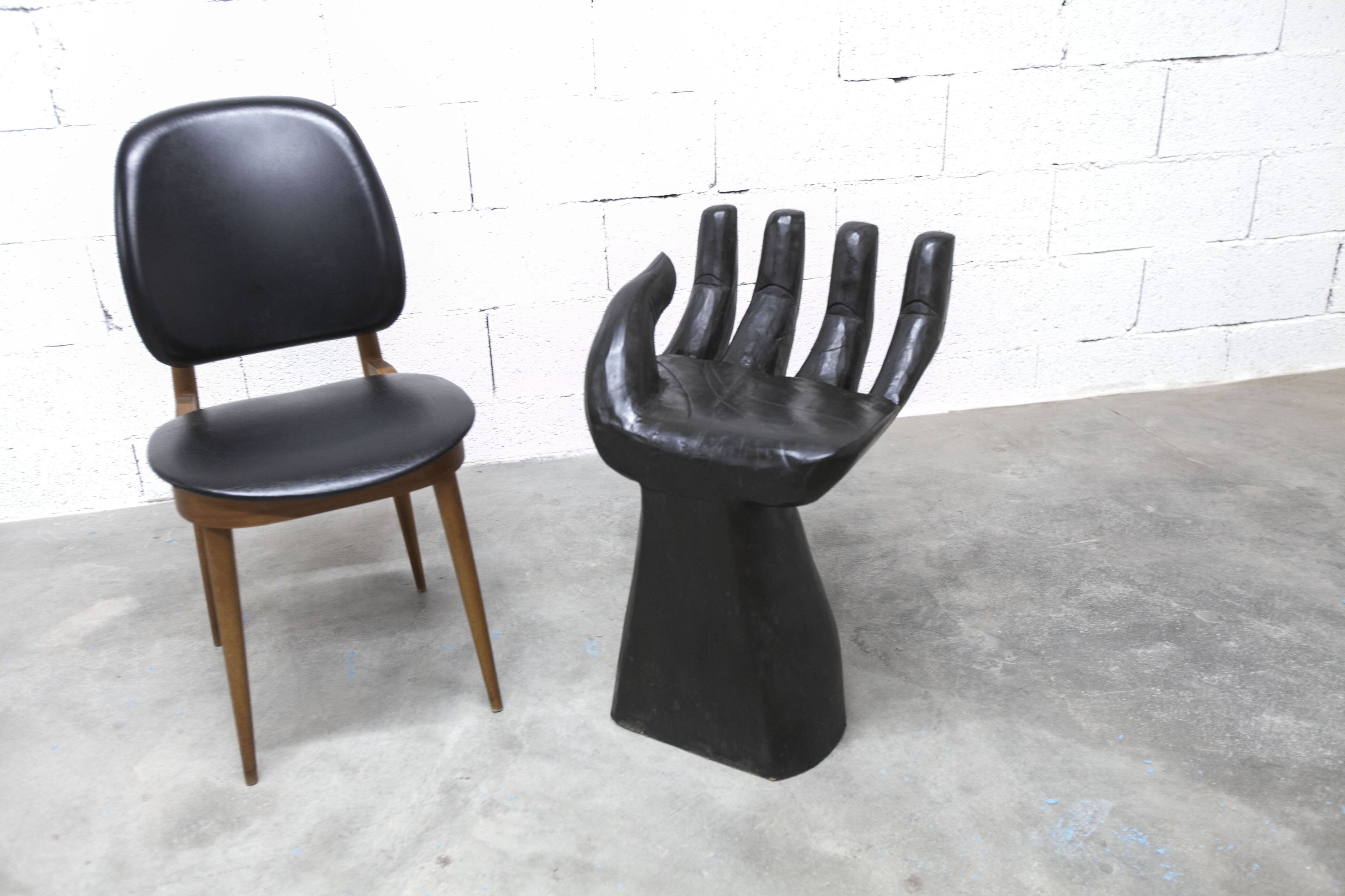 Black armchair chair in carved wood in the shape of a hand