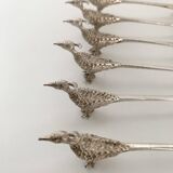 Six silver-plated knife rests in the shape of peacocks.