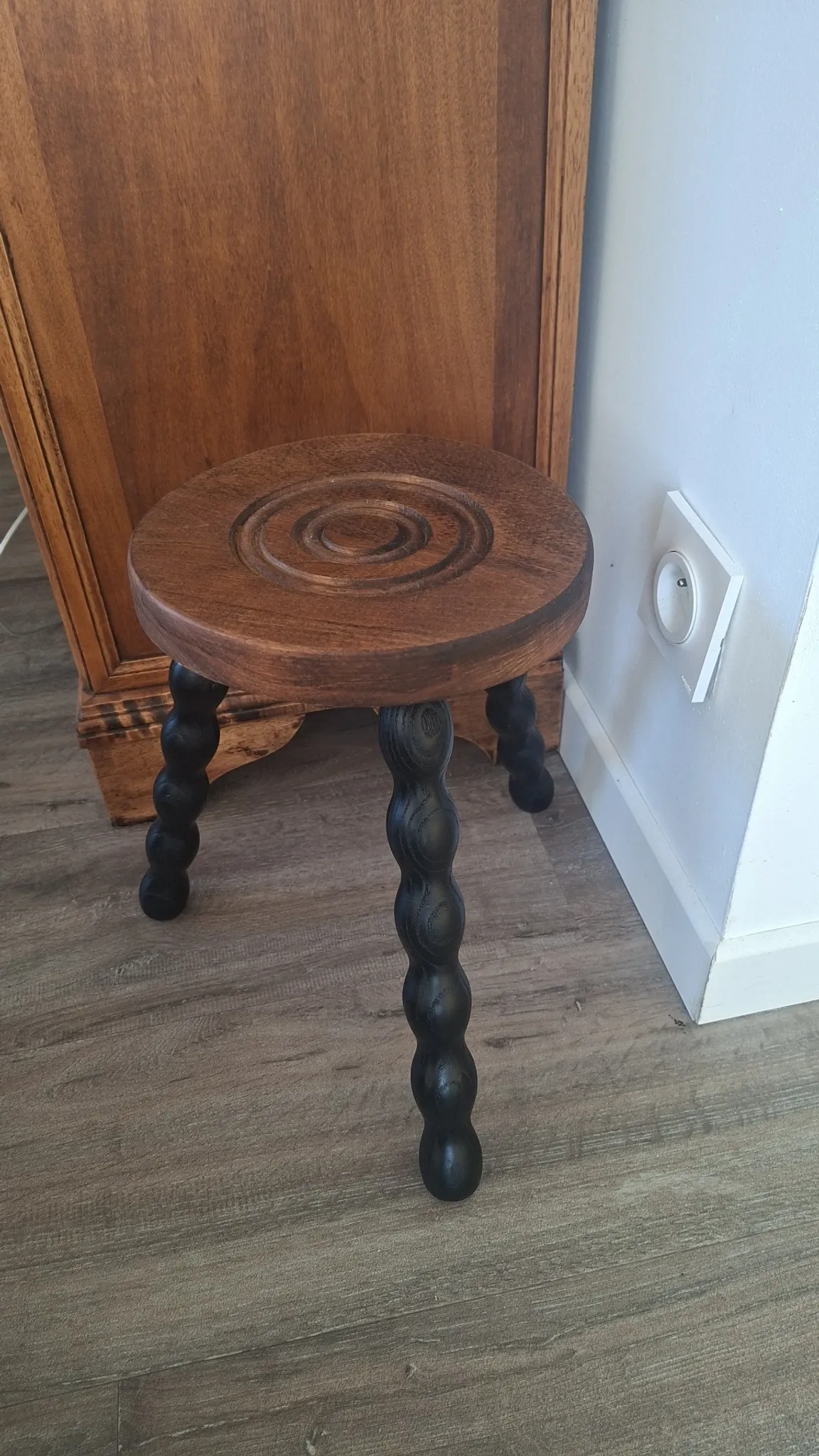 Brown and black wooden tripod stool