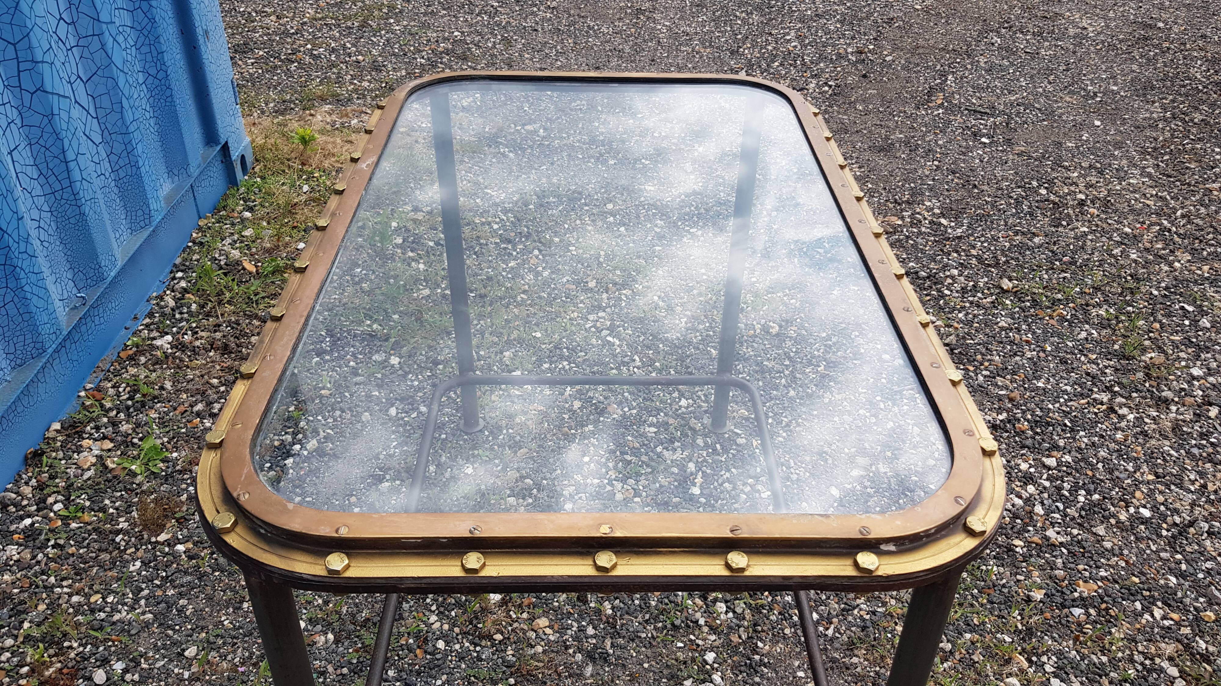 Table with an old ship porthole in brass and a metal base / 110 x 70 x 76 cm