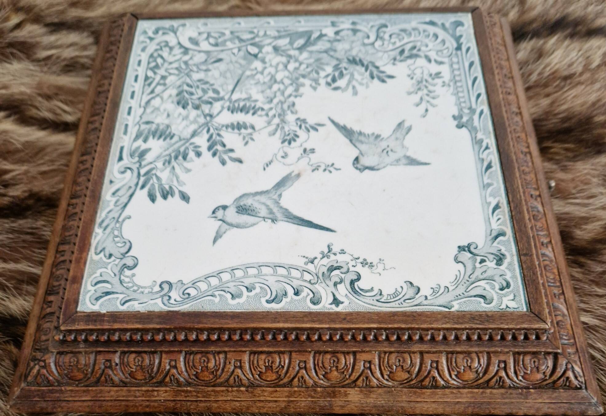 Antique musical trivet made of carved wood and Belle Époque earthenware.