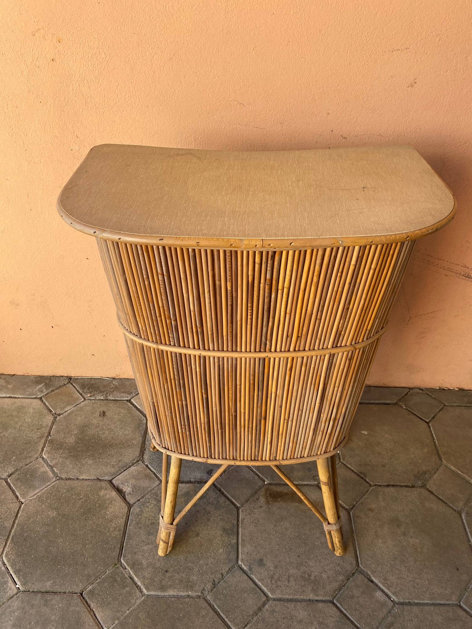 Vintage rattan bar from the 60s with rounded shapes and a shelf for glasses