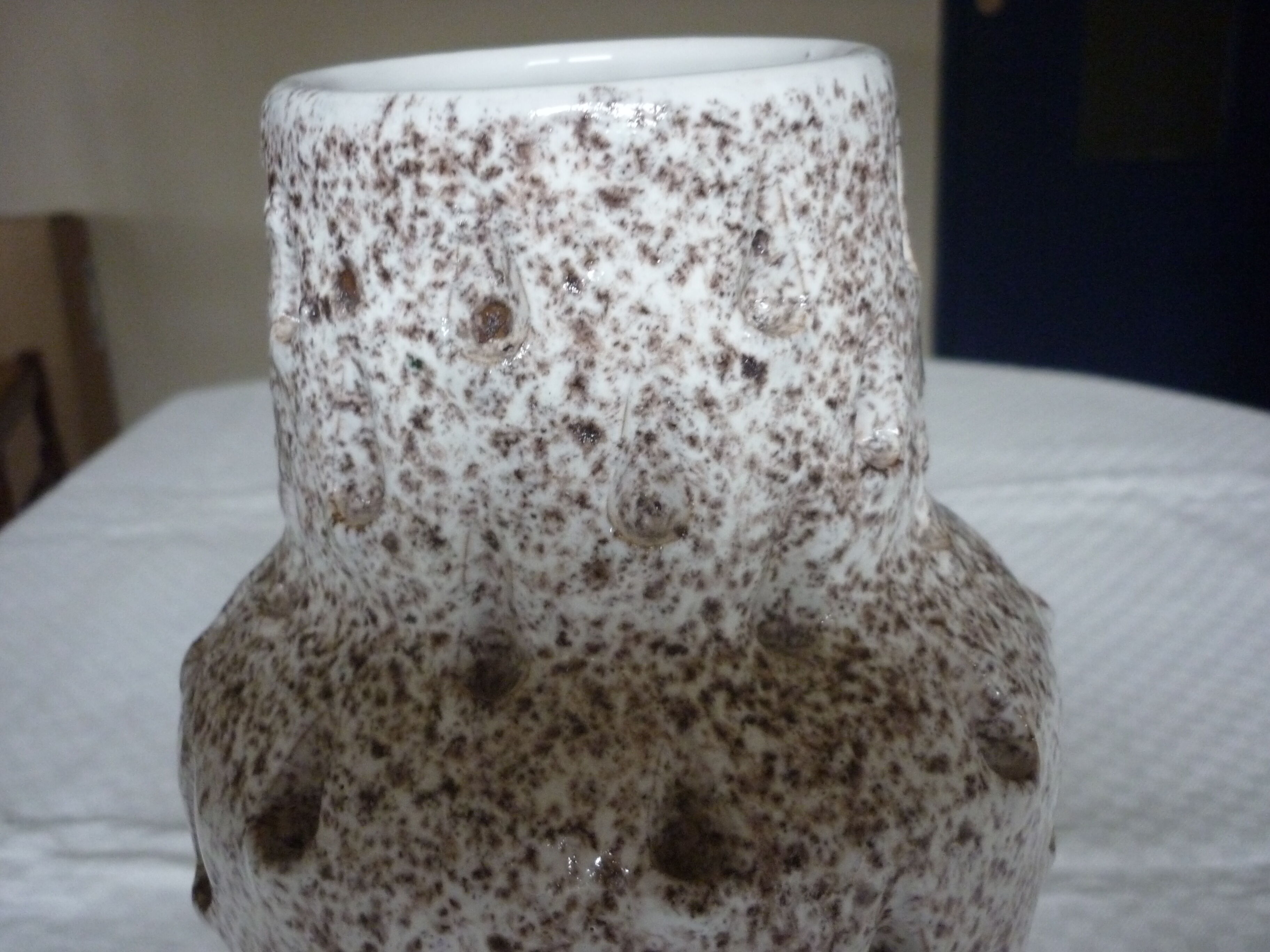 Spotted white ceramic vase with hollow form of tears