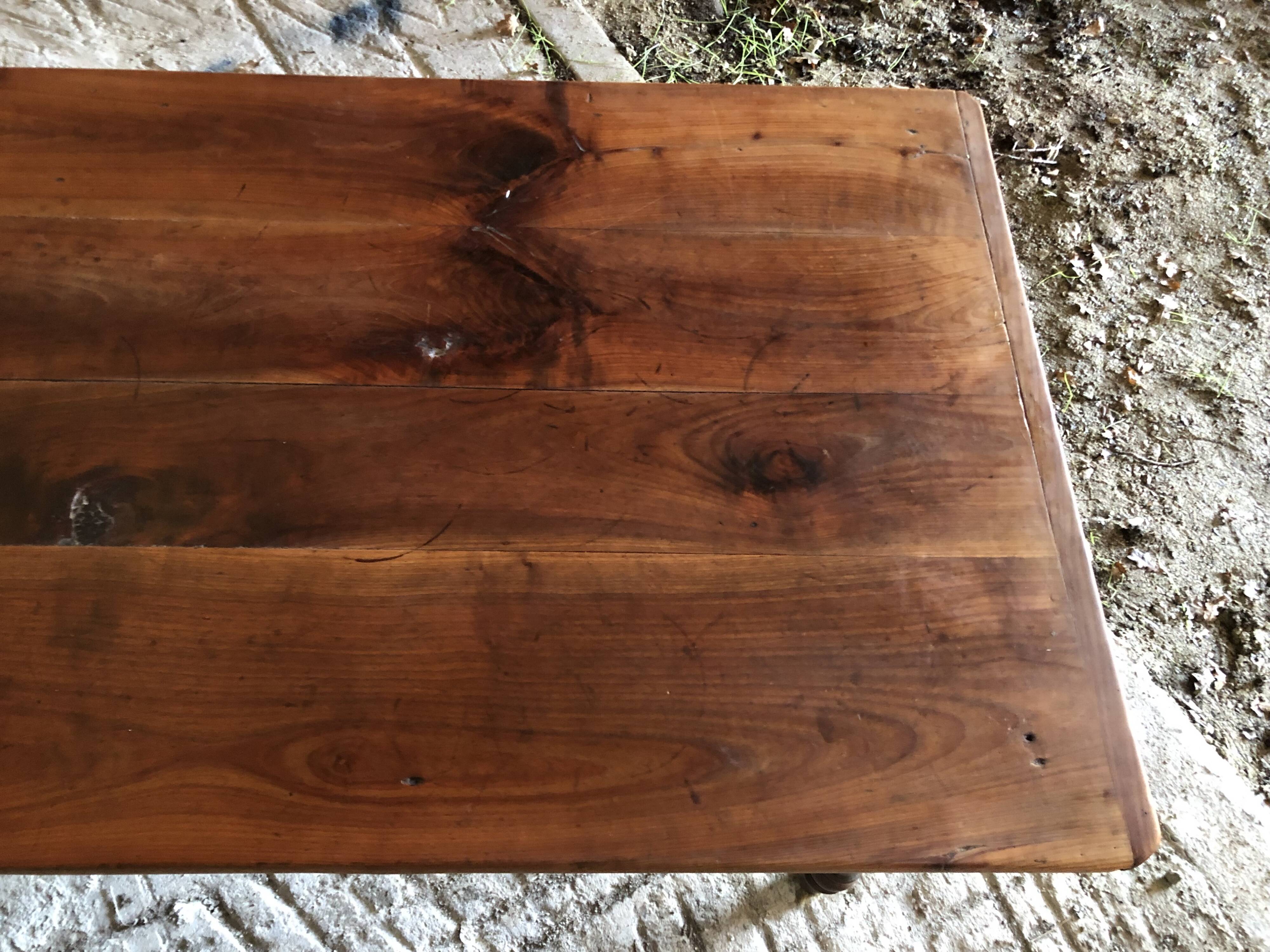 Antique Louis Philippe style farm table in solid cherry wood with turned base.