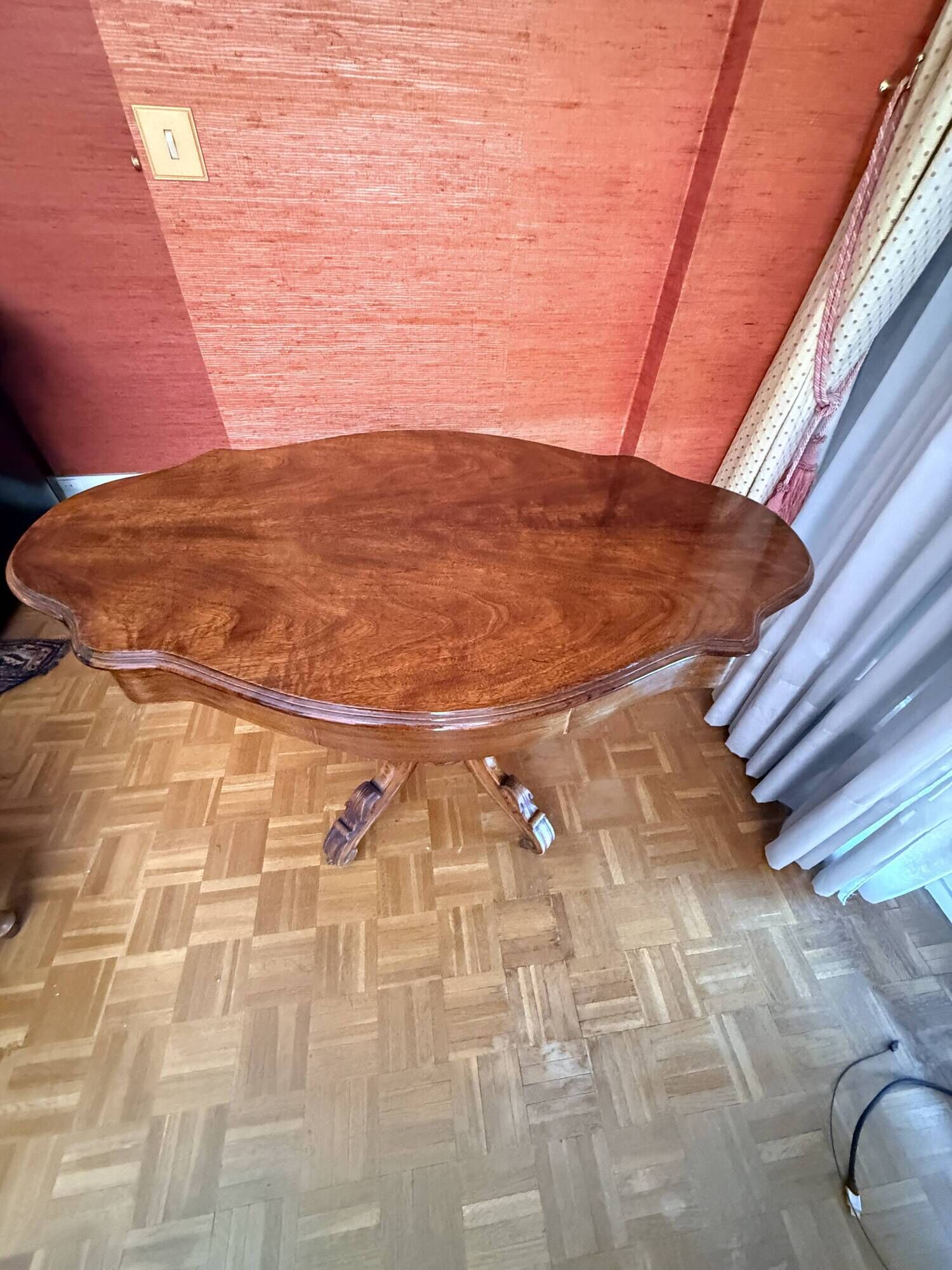 Antique mahogany table with a scalloped top and a sculpted central leg.
