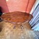 Antique mahogany table with a scalloped top and a sculpted central leg.