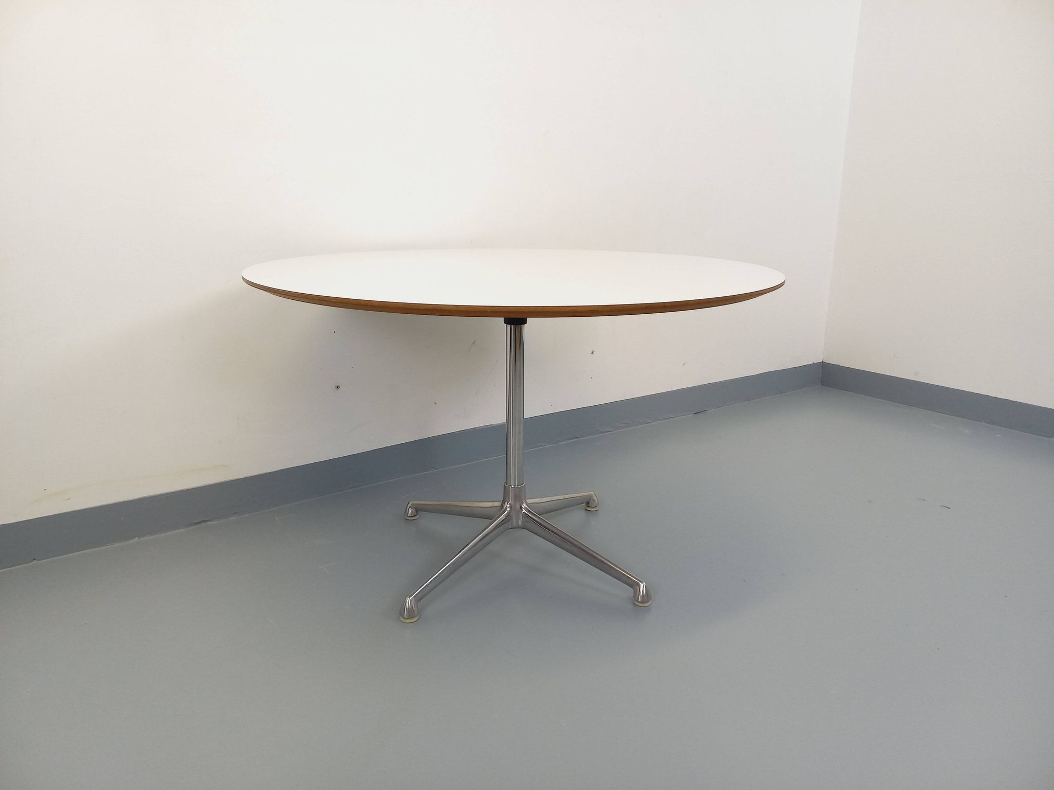 Vintage Eames round table for Vitra in white melamine, wood, and metal.