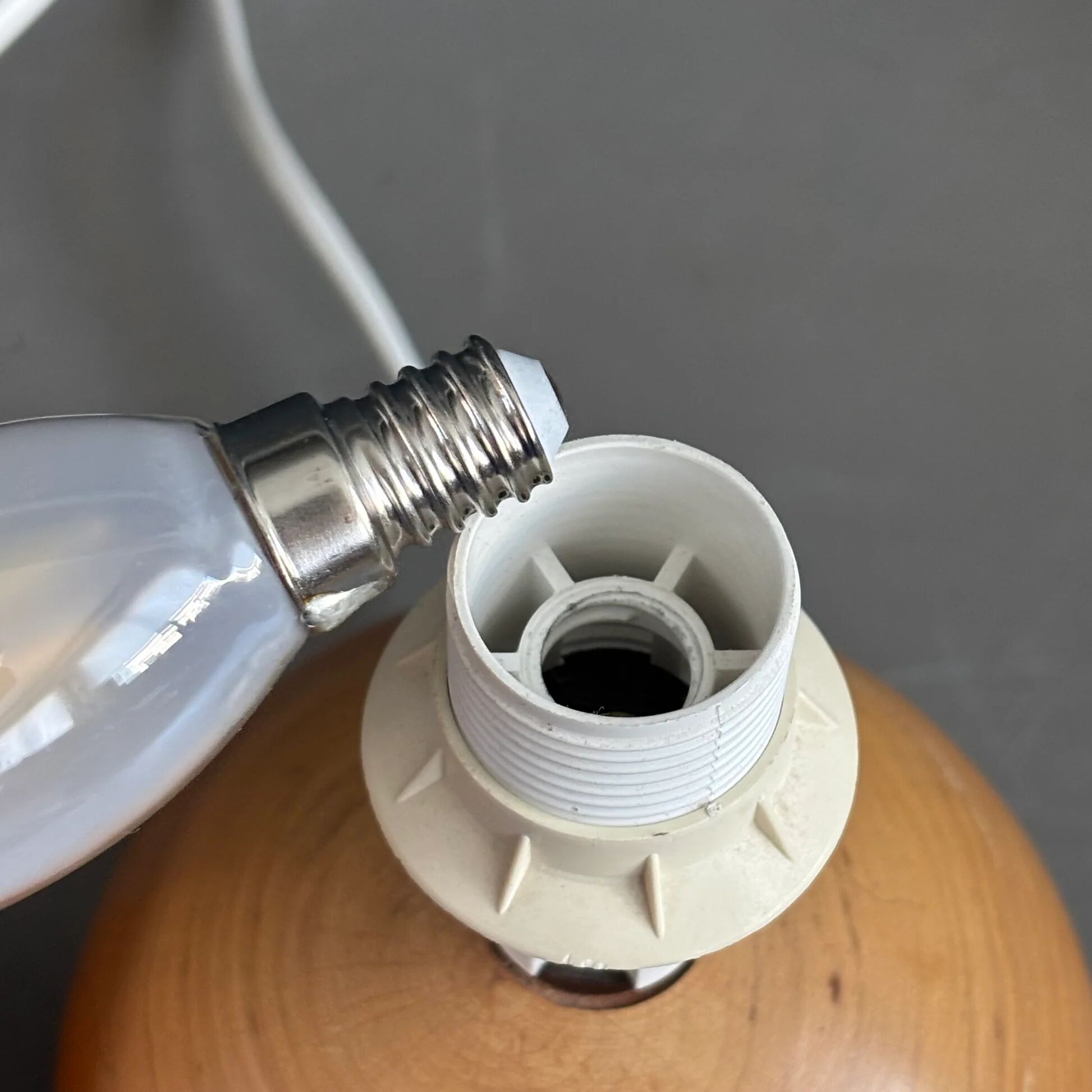 Three wooden ball-shaped lamp stands in light wood.