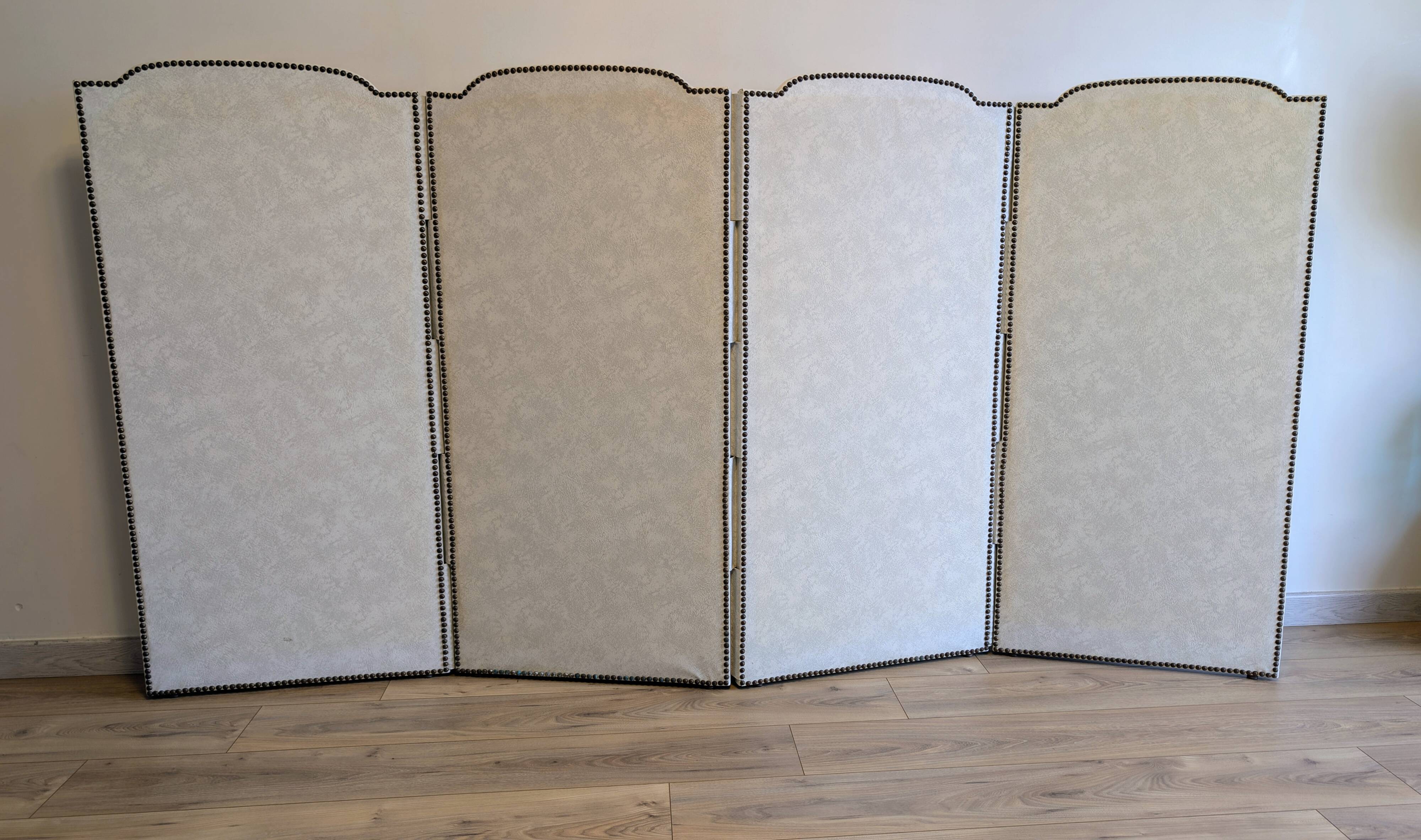 Vintage white faux leather screen with four studded panels, elegant decor.