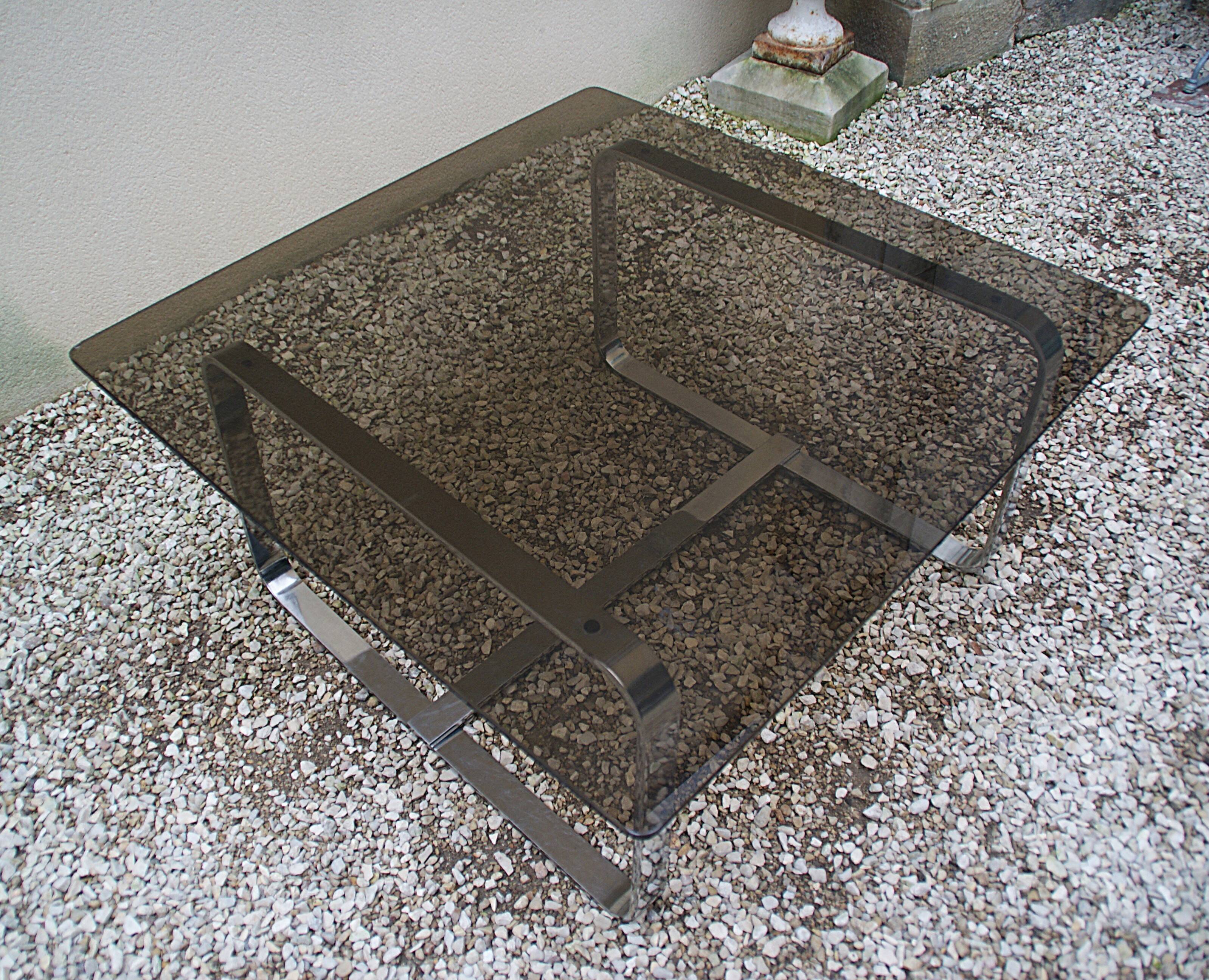 Table basse Roche Bobois 1970 verre fumé piètement en métal chromé.