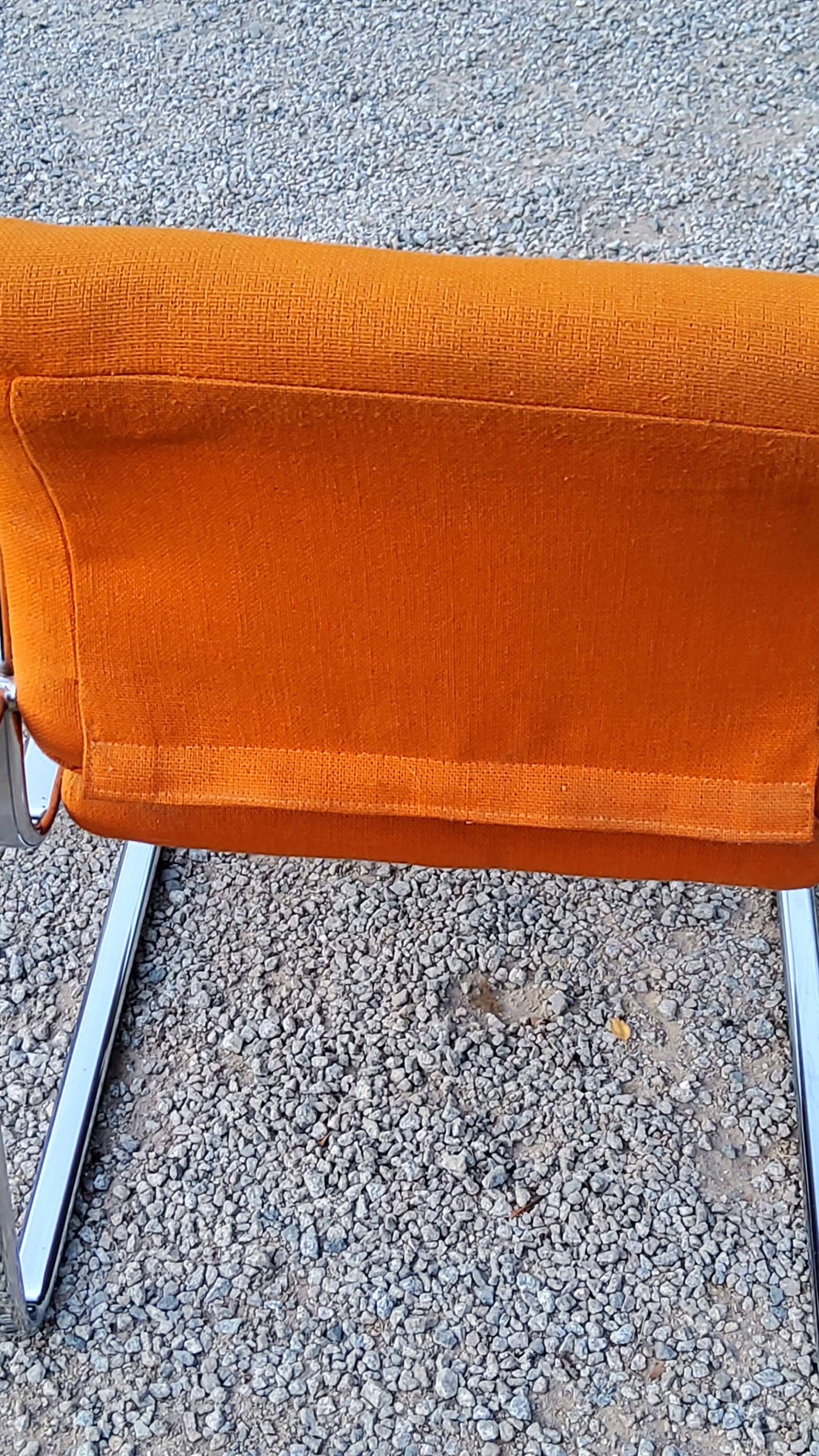 Pair of designer armchairs in orange fabrics and chrome tubes from the 70s