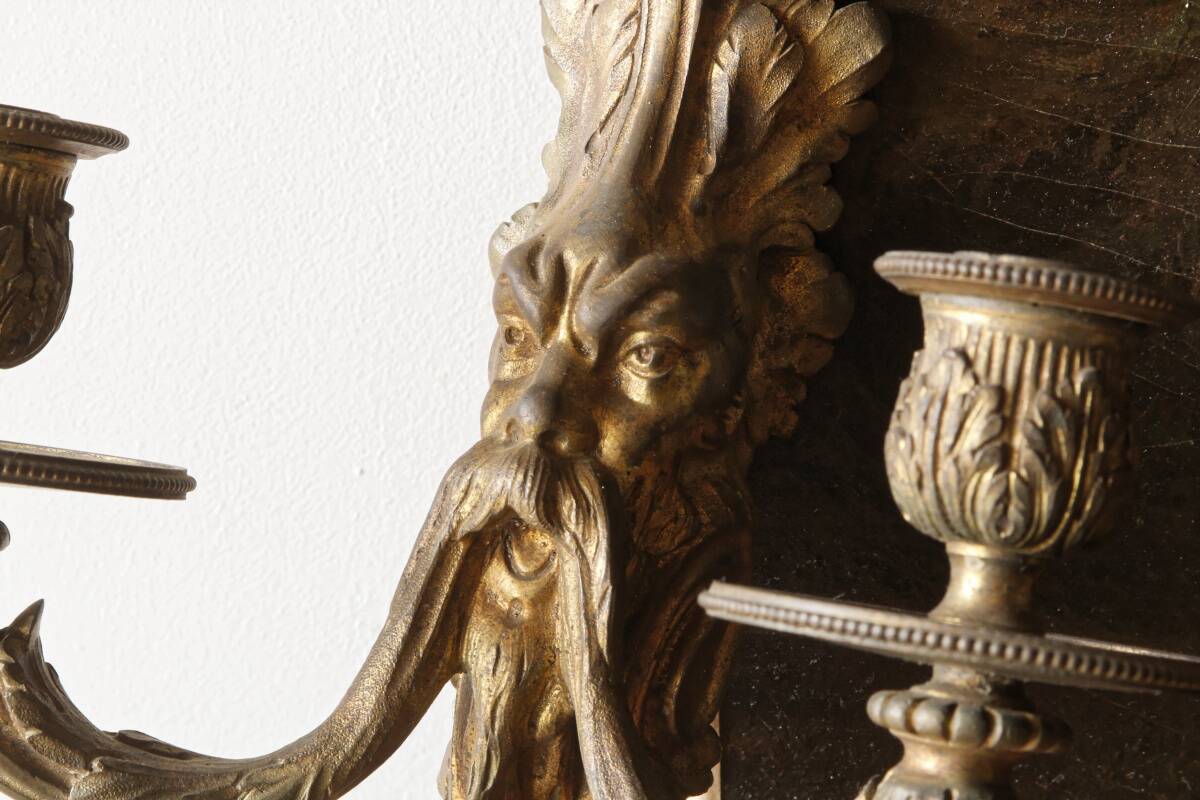 Monobloc gilded bronze wall light, grotesque satyr, two lights.
