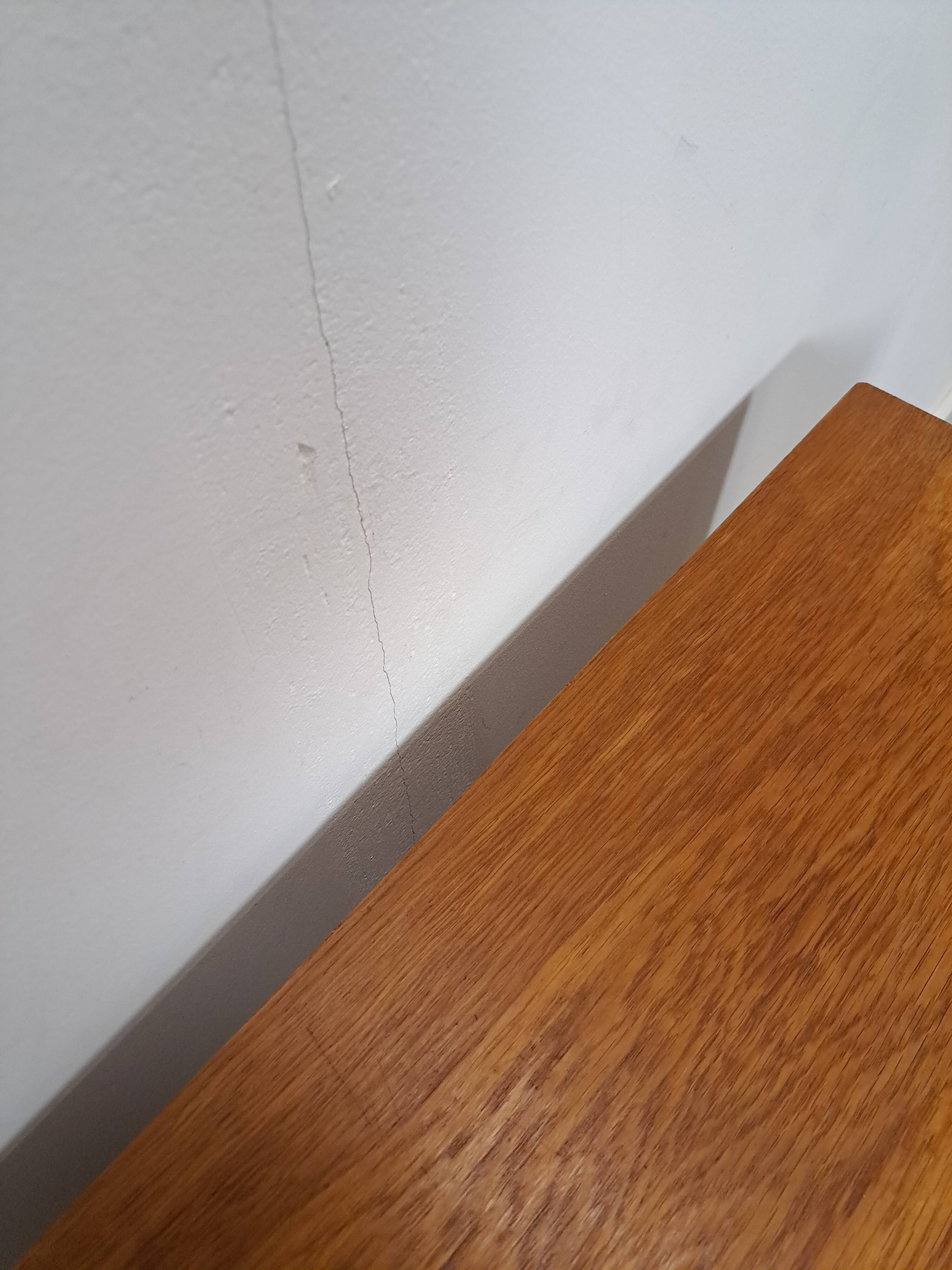 Commode danoise avec de hauts pieds et des poignées dorées.