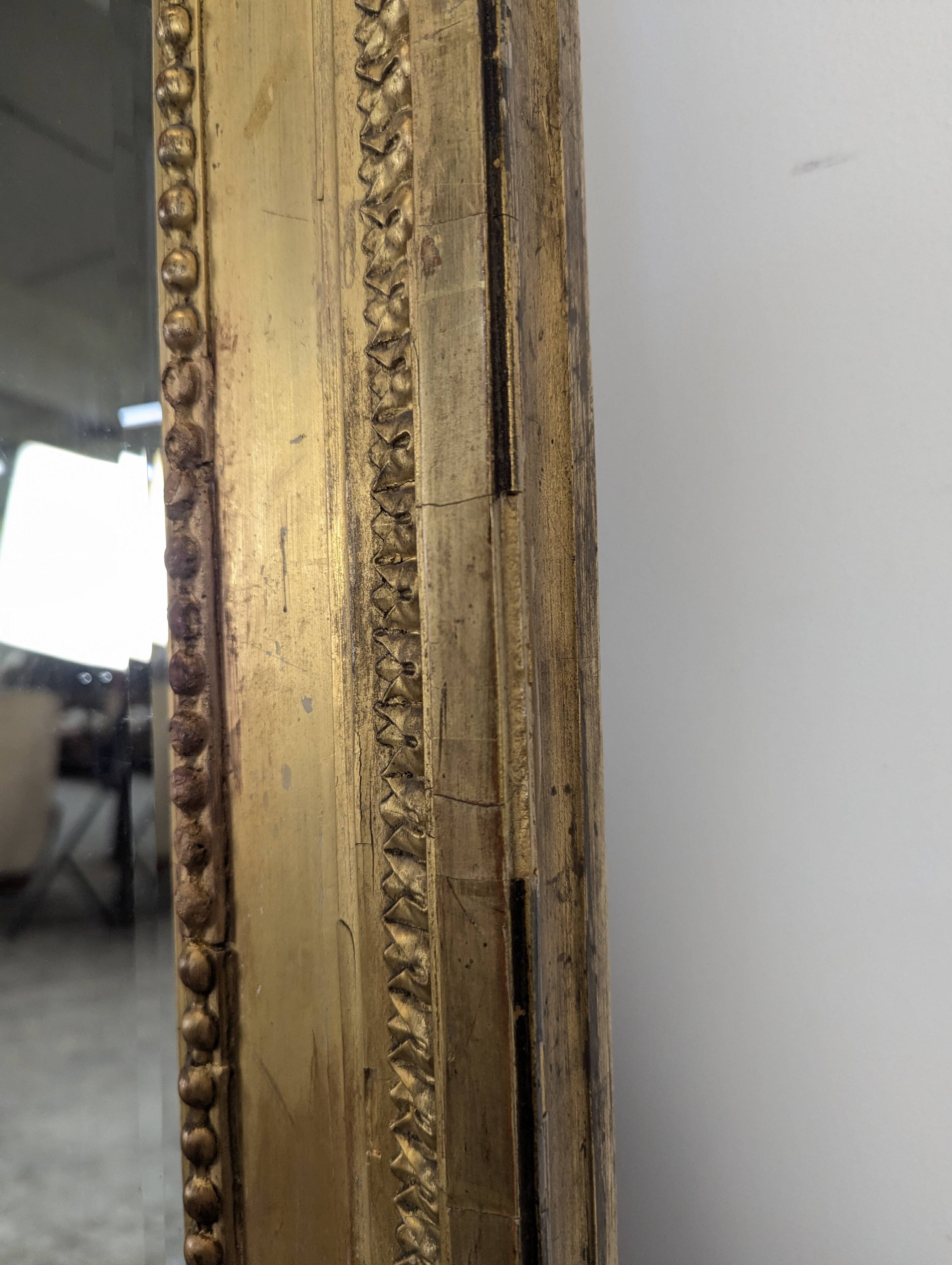 Large gilded wooden mirror in Louis XVI style from the late 19th century.