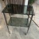 Serving dessert trolley with 2 smoked glass shelves and metal structure.