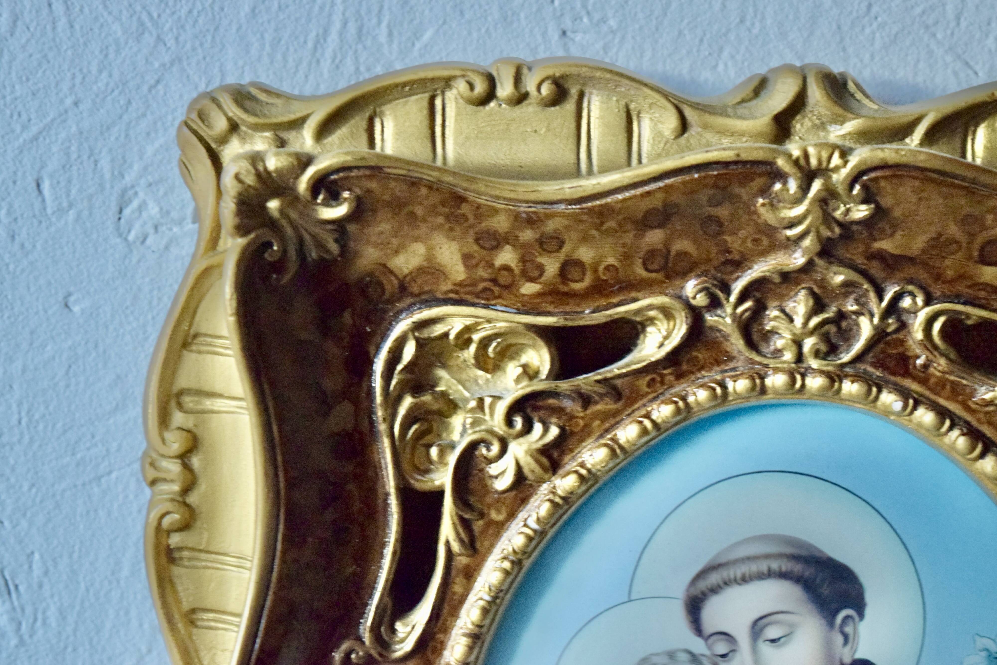 Old religious light frame in gilded stucco and curved glass