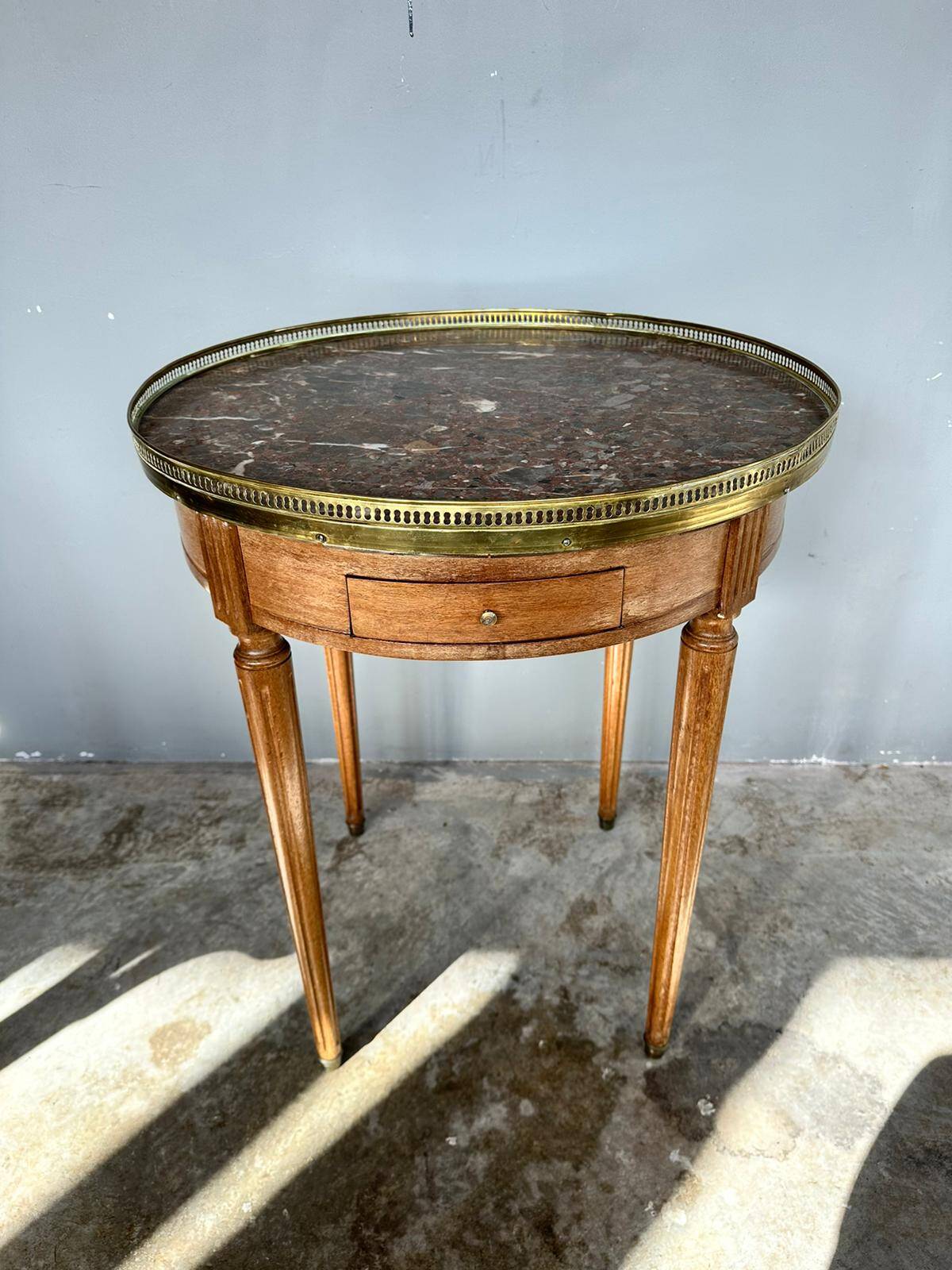 Hot water bottle table with a marble top and a brass gallery.