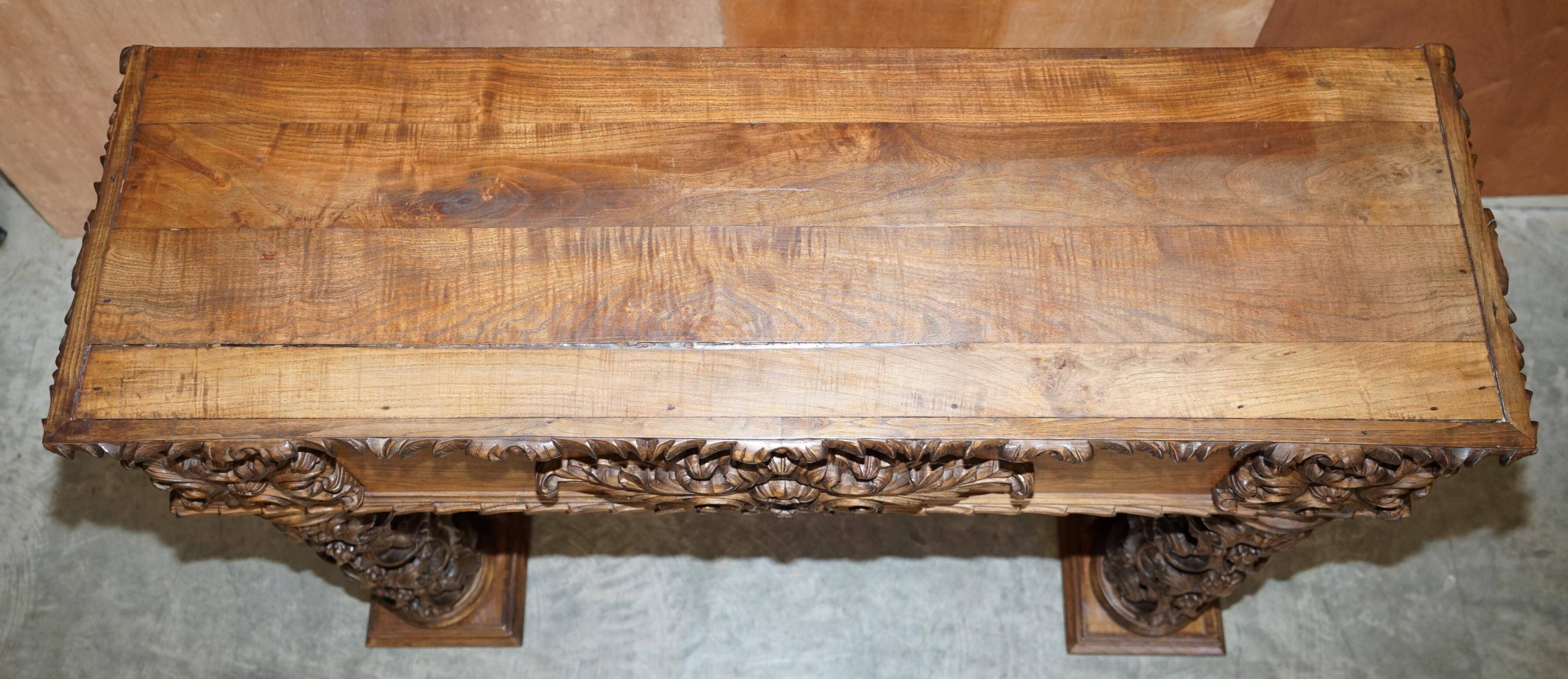 Antique fireplace from around 1880 in solid hand-carved elm with openwork columns.
